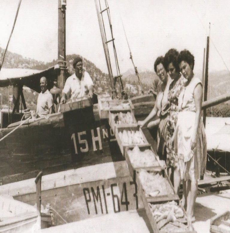 Donne e uomini che scaricano assieme il pescato nel porto di Andratx durante gli anni ’50 del XX secolo