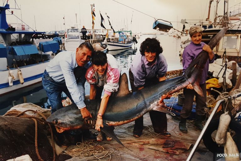 Foto fi famiglia in peschereccio con uno squalo volpe