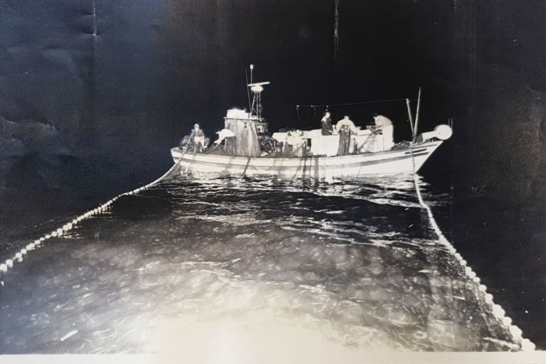 the fishing boat pulls aboard the net that contains the catch